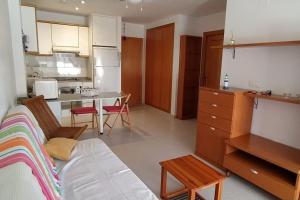 ein Wohnzimmer mit einem Sofa und einer Küche in der Unterkunft Precioso apartamento en Canet d,en Berenger in Canet d'en Berenguer