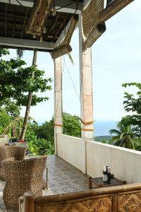 an outdoor patio with chairs and a view of the ocean at The balcony of the camiguin island in Mambajao