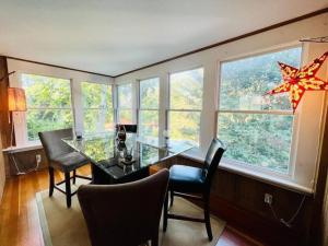 a dining room with a glass table and some windows at Experience Classic New England-walk to beach&shops in Rockport