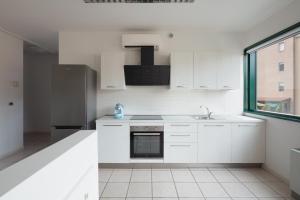 a white kitchen with a sink and a refrigerator at FrenkHome open space in Riolo