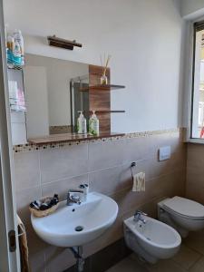bagno con lavandino, servizi igienici e specchio di San Donato apartment a Firenze