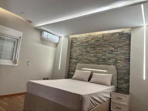 een bed in een kamer met een bakstenen muur bij La Casa Luxurious Smart Home in Caïro