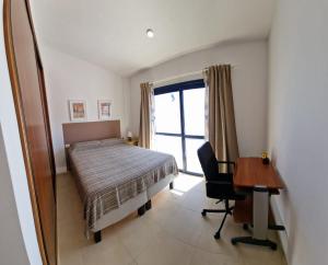 Schlafzimmer mit einem Bett, einem Schreibtisch und einem Fenster in der Unterkunft Terraza del Atlantico 1 + 2 in Barlovento