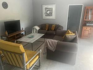 a living room with a couch and a tv at Cosy and Serene Environment in Boksburg