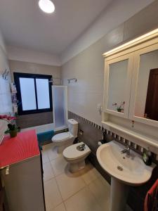 łazienka z 2 umywalkami, toaletą i oknem w obiekcie Terraza del Atlantico 1 + 2 w mieście Barlovento