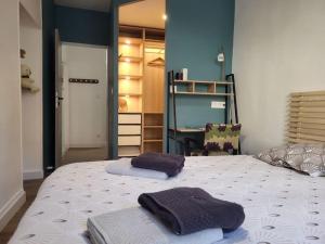 una camera da letto con due asciugamani sopra un letto di Ô Bon'Endroit - Appartement Confort - Centre Ville a Vienne