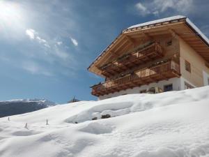 un edificio en la cima de una montaña cubierta de nieve en Biohof Unterstein, en Ultimo