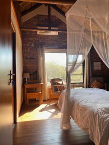 a bedroom with a canopy bed and a window at Nghala Self-catering Holiday Home in Marloth Park
