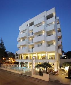 um edifício de apartamentos branco com luzes acesas em Hotel Fantasy em Riccione