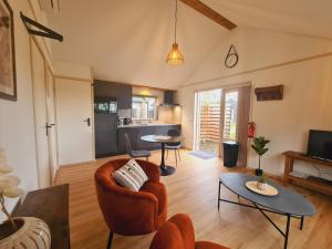 a living room with a couch and a table at 2-persoons luxe vakantiewoning in De Veenhoop