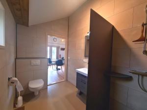 La salle de bains est pourvue de toilettes, d'un lavabo et d'une table. dans l'établissement 2-persoons luxe vakantiewoning, à De Veenhoop