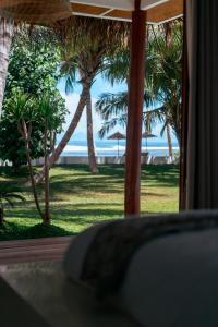 a view of the beach from a resort with palm trees at Villa Onu Mentawai - Private Rooms in Katiet