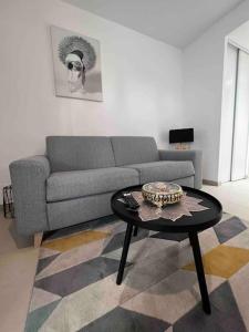 uma sala de estar com um sofá e uma mesa em Le Cosy Corner : Apt 2 pers de standing + Terrasse em Antibes