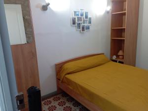 um pequeno quarto com uma cama com uma colcha amarela em Maison entière Coeur village em Argelès-sur-Mer