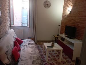 uma sala de estar com uma cama e uma televisão em Maison entière Coeur village em Argelès-sur-Mer