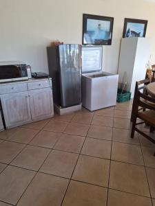 a kitchen with a large tiled floor with a refrigerator at Fairview Accommodation in Gansbaai