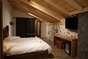ErsekëにあるSofra Kolonjareのベッドルーム(ベッド1台、デスク、テレビ付)