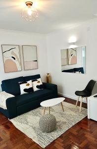 een woonkamer met een zwarte bank en een tafel bij Cantinho do Castelo in Bragança