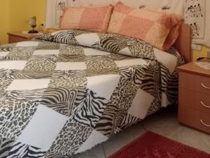 een bed met een zwart-wit dekbed en kussens bij Casa TildePino davanti al fiume Temo in Bosa