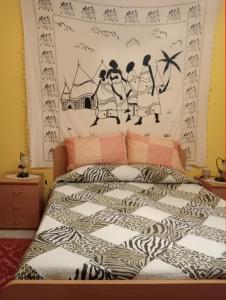 een slaapkamer met een bed met een zwart-wit dekbed bij Casa TildePino davanti al fiume Temo in Bosa