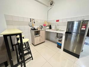 a kitchen with a stainless steel refrigerator and a counter at KK City A2Z Api Api Modern Studio Homestay in Kota Kinabalu