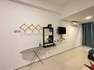 Habitación con mesa y espejo en la pared. en KK City A2Z Api Api Modern Studio Homestay en Kota Kinabalu