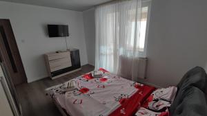 a room with a bed with a table with roses on it at A&A Residence in Piatra Neamţ
