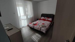 a small bedroom with a bed with a red blanket at A&A Residence in Piatra Neamţ