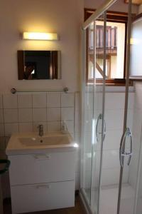 a bathroom with a sink and a shower with a mirror at Gîte Le Bressaud in La Bresse