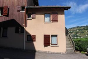 un edificio con puertas marrones y escaleras. en Gîte Le Bressaud, en La Bresse