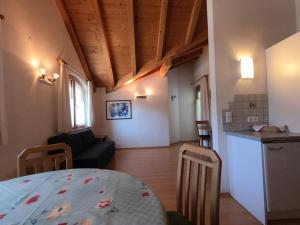 eine Küche und ein Wohnzimmer mit einem Tisch im Zimmer in der Unterkunft Residence Emma in Toblach
