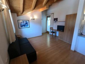 uma ampla sala de estar com um sofá e uma secretária em Residence Emma em Dobbiaco