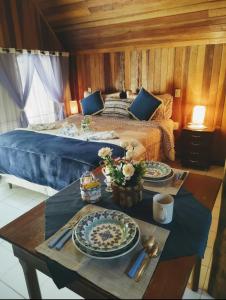 Un dormitorio con una cama y una mesa con platos. en Pousada ao nascer do sol en Gonçalves