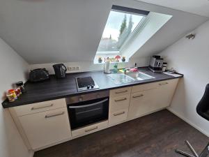una pequeña cocina con fregadero y ventana en Ferienwohnung Klettham en Erding