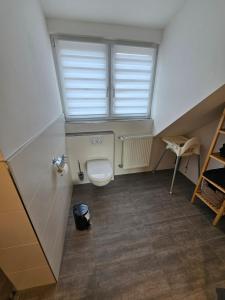 a small bathroom with a toilet and a window at Ferienwohnung Klettham in Erding