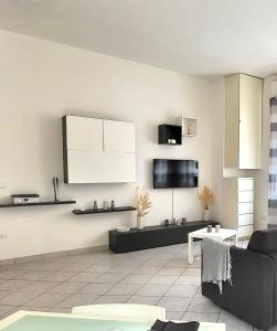 uma sala de estar com um sofá e uma televisão em White Home Forli Centro em Forlì