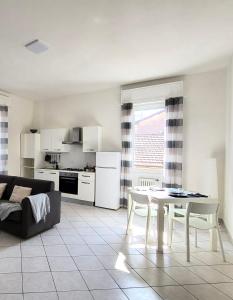 uma sala de estar branca com uma mesa e uma cozinha em White Home Forli Centro em Forlì