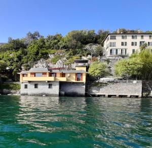 a house on the water next to a building at Villa del Pescatore in San Siro