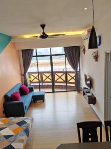 a living room with a blue couch and a table at Homestay Melaka at Mahkota Hotel - unit 3093 - FREE Wifi & Parking in Melaka