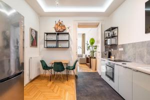 a kitchen with a table and green chairs at Aviator luxury apartment in the city center in Budapest