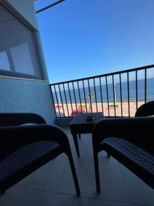 XgħajraにあるSG seaview apartmentのビーチの景色を望むバルコニー(テーブル付)