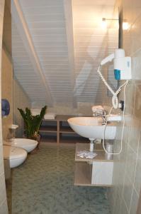 a bathroom with a sink and two toilets at Sempione Hotel Malpensa in Casorate Sempione