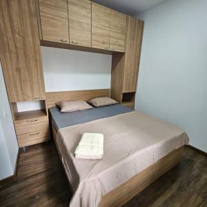 ein Schlafzimmer mit einem großen Bett mit Holzböden und Schränken in der Unterkunft 2 Bedroom Central Apartment in Chişinău