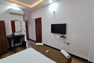 a room with a bed and a flat screen tv on a wall at zoz Baga in Baga