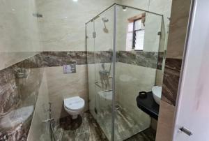 a bathroom with a glass shower and a toilet at zoz Baga in Baga