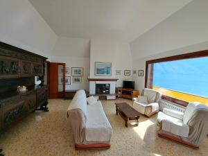 een woonkamer met witte meubels en een groot raam bij Villa del Pescatore in San Siro