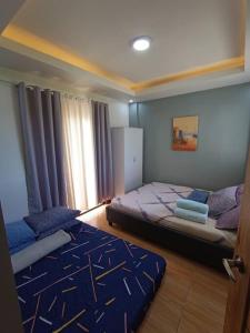 1 Schlafzimmer mit 2 Betten und einem Fenster in der Unterkunft Magnilay Villa by Asher and Caleb w/ Pool Tagaytay in Mendez-Nuñez