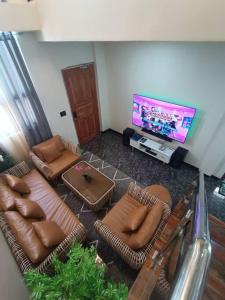 ein Wohnzimmer mit Sofas und einem Flachbild-TV in der Unterkunft Magnilay Villa by Asher and Caleb w/ Pool Tagaytay in Mendez-Nuñez