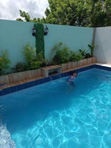 Ein Junge im Pool im Schwimmbad. in der Unterkunft Magnilay Villa by Asher and Caleb w/ Pool Tagaytay in Mendez-Nuñez