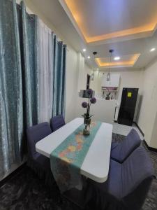 Zimmer mit einem weißen Tisch und lila Stühlen in der Unterkunft Magnilay Villa by Asher and Caleb w/ Pool Tagaytay in Mendez-Nuñez